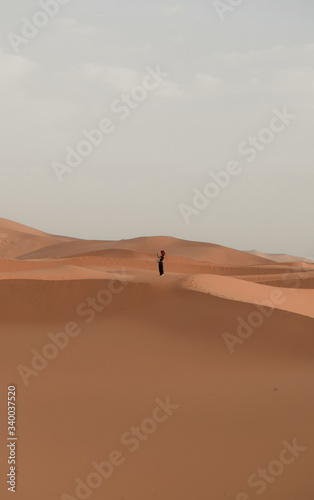 Una mujer mira el horizonte en el desierto del sahara