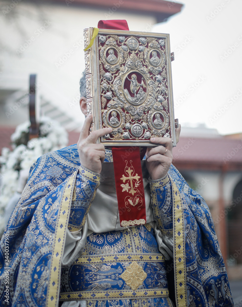 Φωτογραφία Shallow depth of field (selective focus) details with a Romanian orthodox christian priest holding a Holy Bible outside a church
