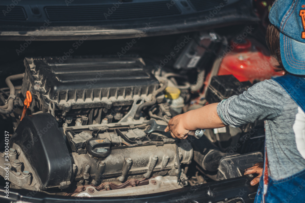 childs hand trying fix broken car. Close up under the hood of a car childs hand trying fix broken car. Close up under the hood of a car