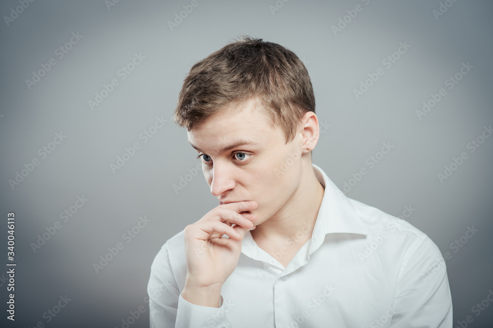 Closeup portrait of a young handsome man biting his finger nails with a craving for something or anxious. Negative human emotion facial expression feeling Closeup portrait of a young handsome man biting his finger nails with a craving for something or anxious. Negative human emotion facial expression feeling