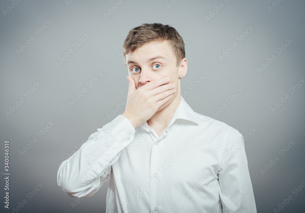 Emotional man keep his mouth closed by his hands Emotional man keep his mouth closed by his hands