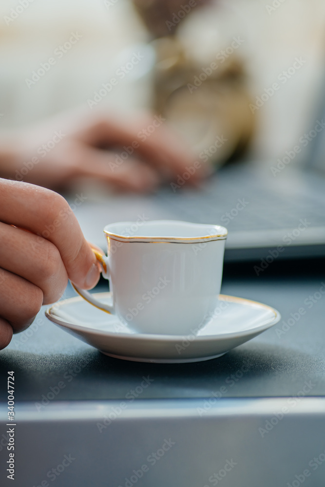 Man works in bussiness office with computer or laptop or notebook and papper graf and he drinks coffee Man works in bussiness office with computer or laptop or notebook and papper graf and he drinks coffee