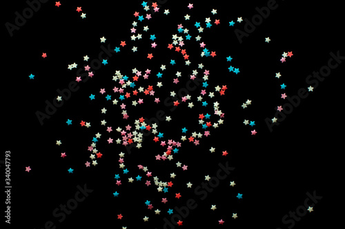 multicolored confectionery sprinkle in the form of stars on a black background