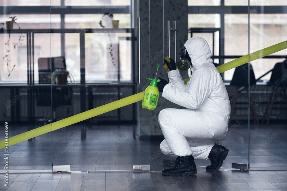 Obraz premium Cleaning and Disinfection at town complex amid the coronavirus epidemic. Professional teams for disinfection efforts. Infection prevention and control of epidemic. Protective suit and mask