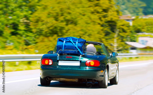 Cabriolet with luggage bag on road in Switzerland reflex