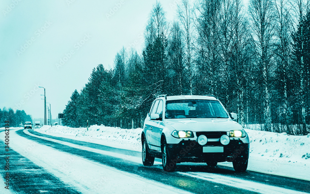 Car on the road at snowy winter Lapland reflex
