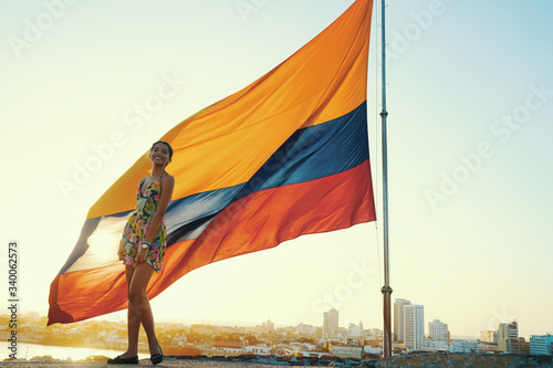 mujer y bandera colombiana en dorado atardecer photo