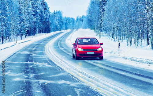 Red Car in road in winter Rovaniemi reflex