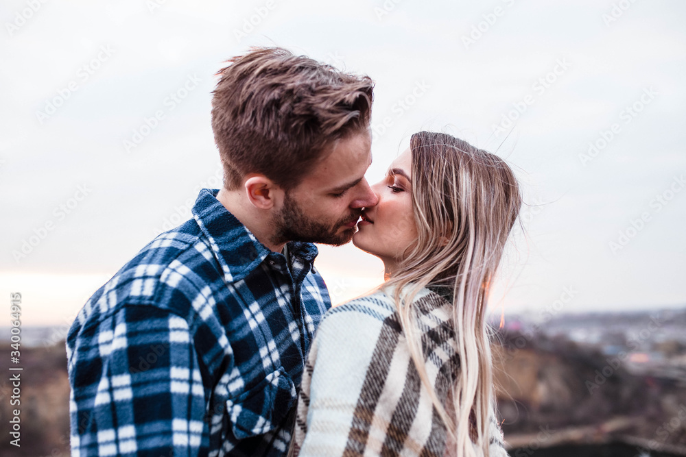 Young couple kissing at sunset. Man and woman. Man in shirt . Camping. Young couple kissing at sunset. Man and woman. Man in shirt . Camping.