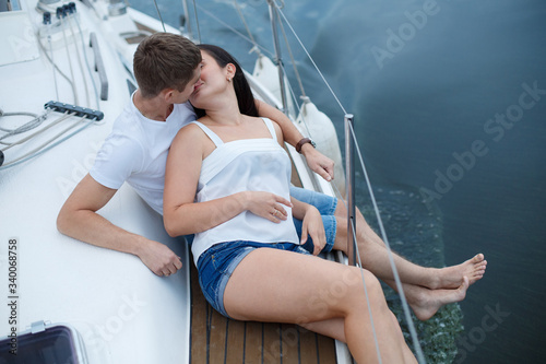 love story in nautical topics aboard the yacht. passionatehappy couple in love hugging and kissing on  sea water background. Romantic date on seafront. emotional man and woman have fun aboard the boat © mihail_pustovit