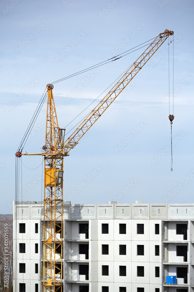 One construction crane are building a new residential building. Construction and real estate
