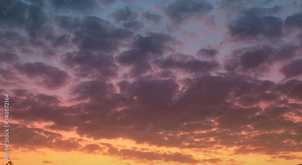 Sunset sky, big clouds. Orange violet colors