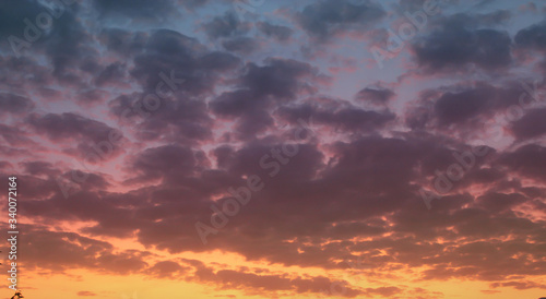 Sunset sky  big clouds. Orange violet colors