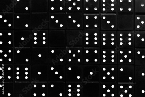 Black dominoes with white dots. Abstract solid background. Random order.