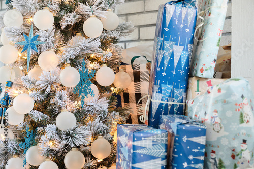 Christmas Holiday ornaments on a Christmas tree surrounded by wrapped gifts photo