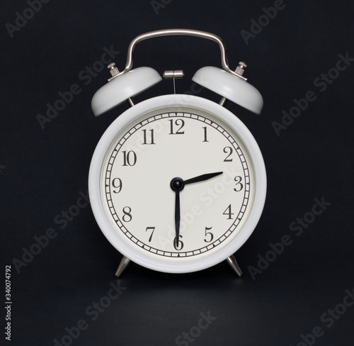 Old-style alarm clock, black and white, it's half past two.