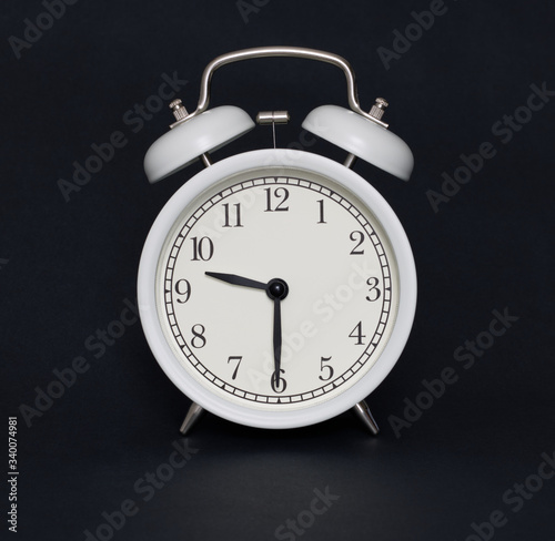 Old-style alarm clock, black and white, it's half past nine.