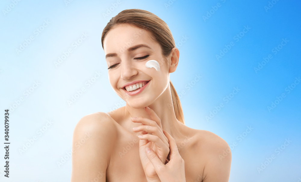 Young woman with sun protection cream on face against light background Young woman with sun protection cream on face against light background