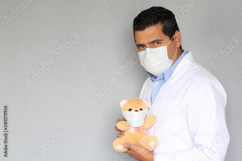 Doctor Pediatra con oso de peluche con cubrebocas  photo