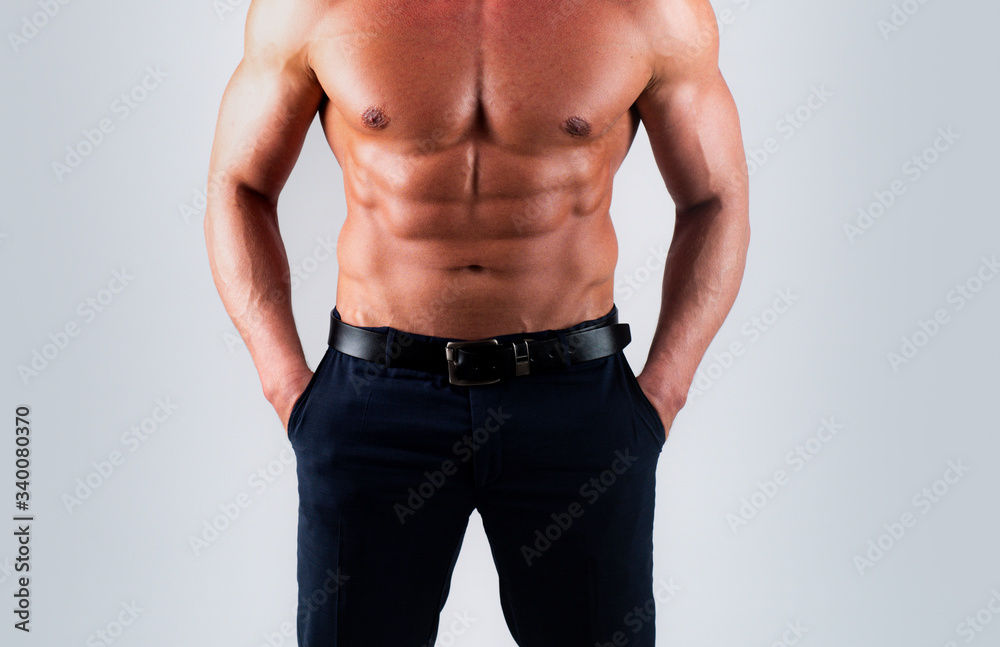 Torso man with six pack. Model man on gray background. Strong brutal guy with sexy torso. Sport workout concep.