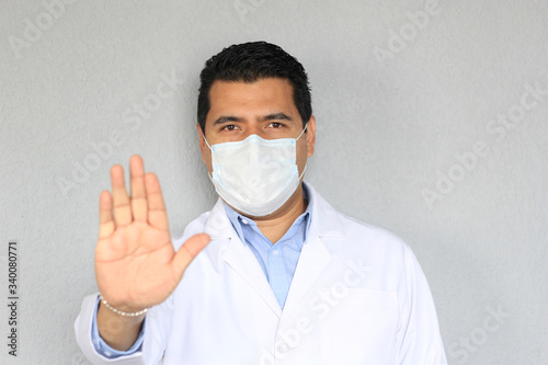 Doctor con bata y cubrebocas, alto a la pandemia covid-19 photo