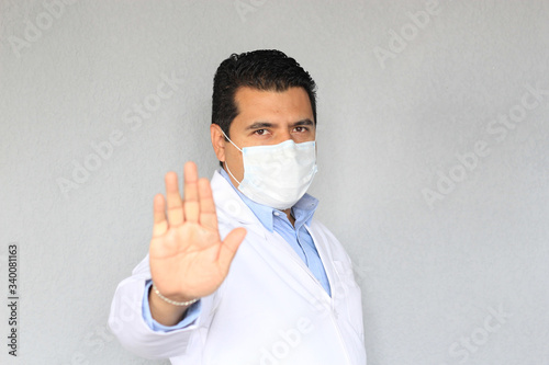 Doctor con bata y mascara de proteccion uso clinico, alto a la pandemia covid-19 photo