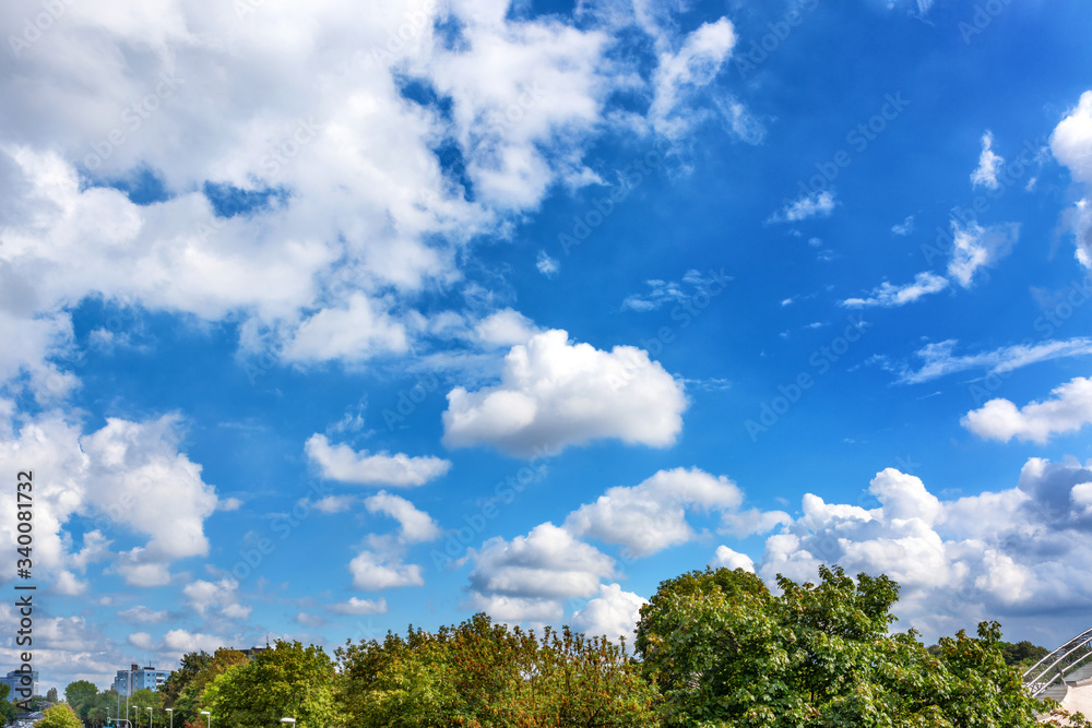 Fluffy white clouds on background of blue sky over the park. Fluffy white clouds on background of blue sky over the park.