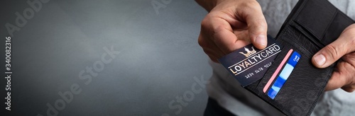 Person Removing Loyalty Card From Wallet photo