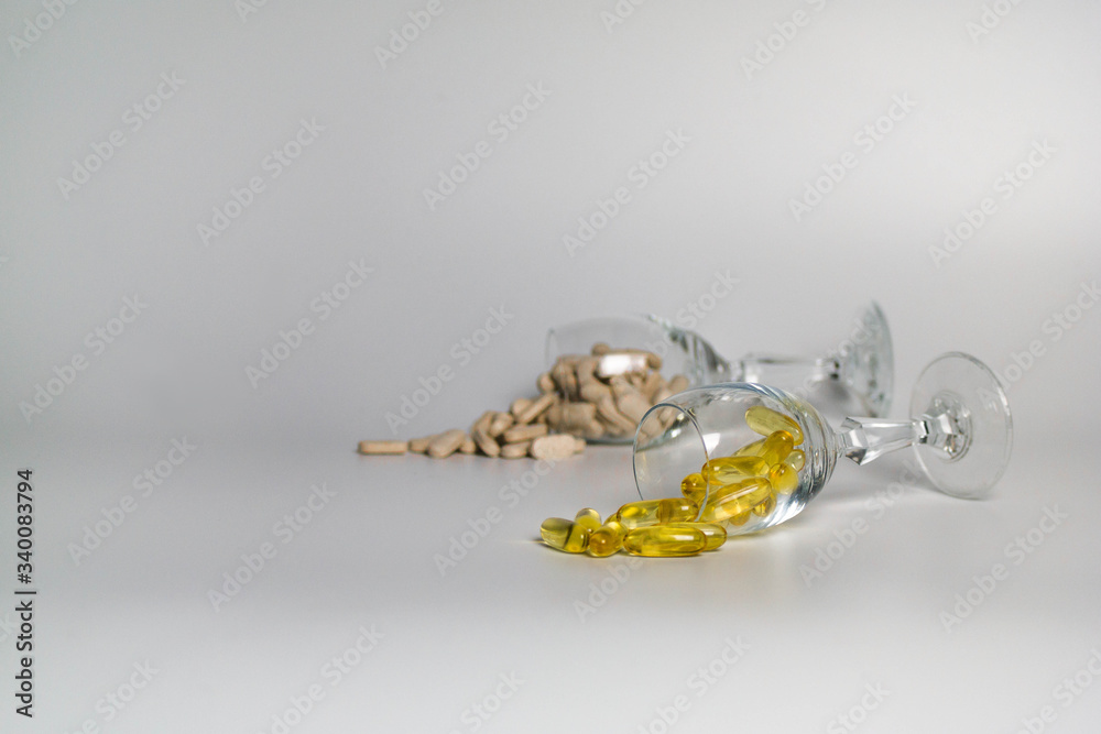 Two glasses full of capsules on a white background