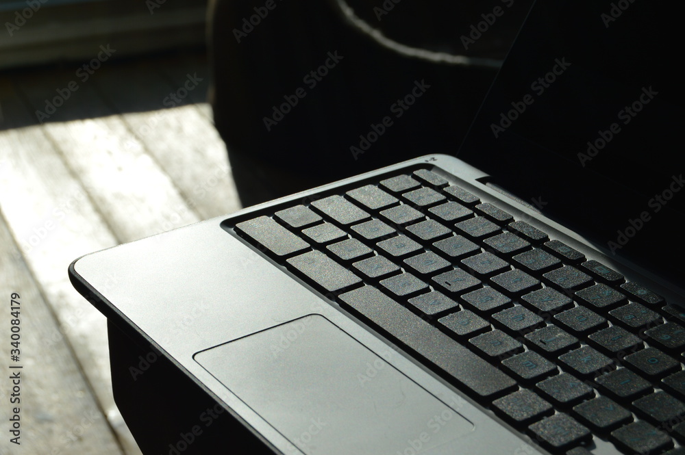 Laptop on a wooden table. Work space. Old technology. Mouse pad on a laptop.  Keyboard layout of a laptop. Stock Photo | Adobe Stock