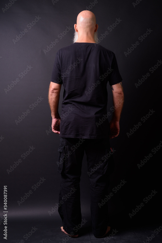 Mature bald bearded man against black background Mature bald bearded man against black background