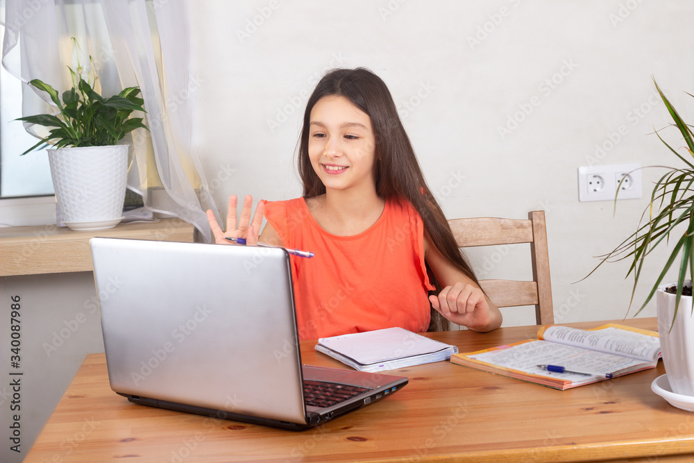Self-isolated girl talking to teacher online and doing homework, watching webinar at laptop. Distance education, homeschooling, E-learning at home during quarantine concept Self-isolated girl talking to teacher online and doing homework, watching webinar at laptop. Distance education, homeschooling, E-learning at home during quarantine concept