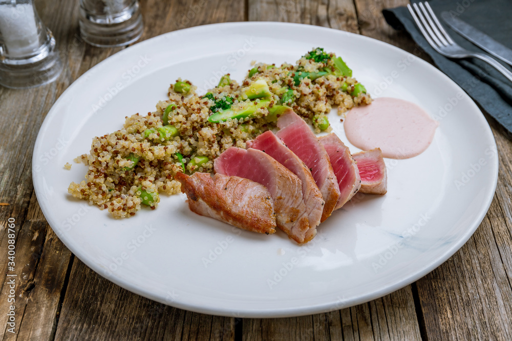grilled tuna fillet with Salmon quinoa on wooden table grilled tuna fillet with Salmon quinoa on wooden table