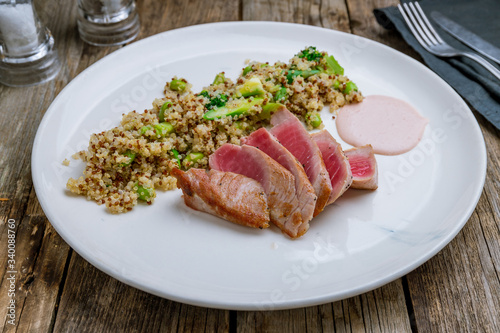 grilled tuna fillet with Salmon quinoa on wooden table