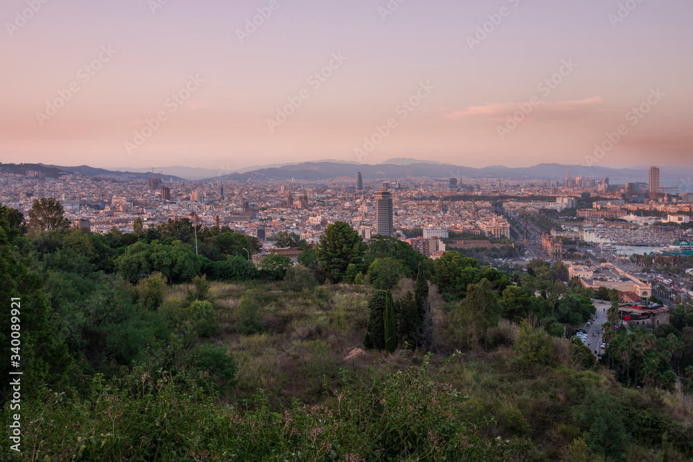 Barcelona skyline during sunset from city park Jardins del Mirador, mountain Montjuic, Spain .