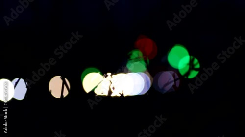 Real camera bokeh, blurry out of focus, of a busy city street with traffic lights and cars passing by. The concept of the lights of the night city.