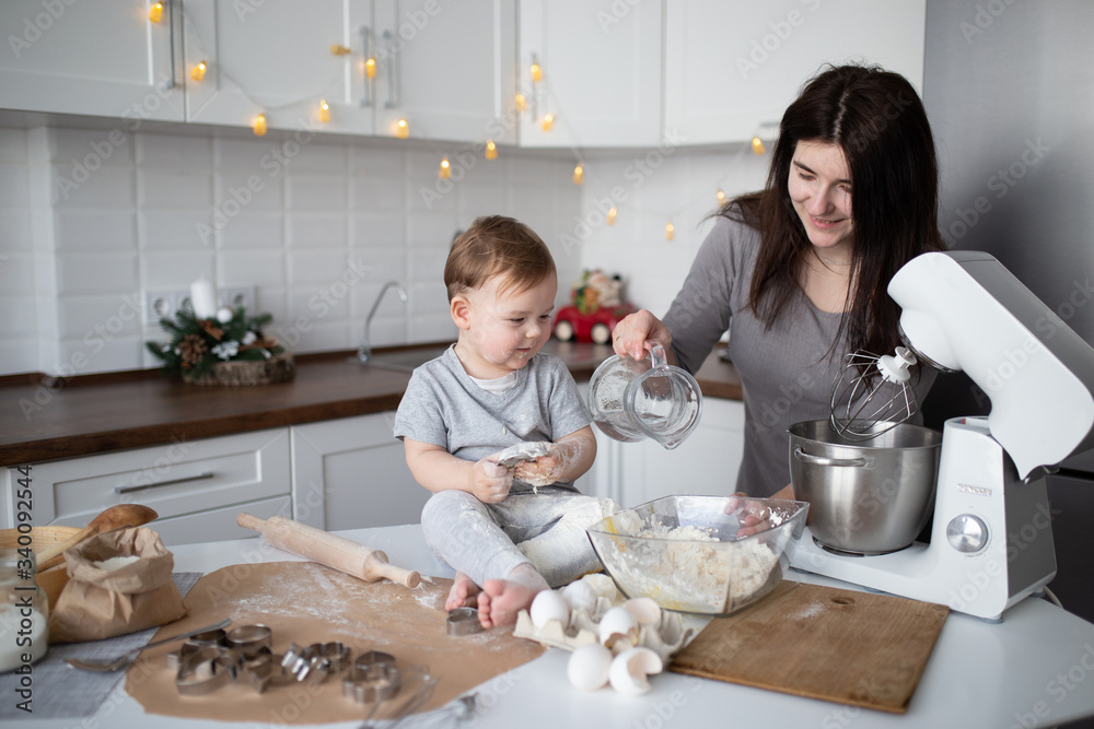 happy family in the kitchen. mother and son preparing the dough, bake cookies happy family in the kitchen. mother and son preparing the dough, bake cookies