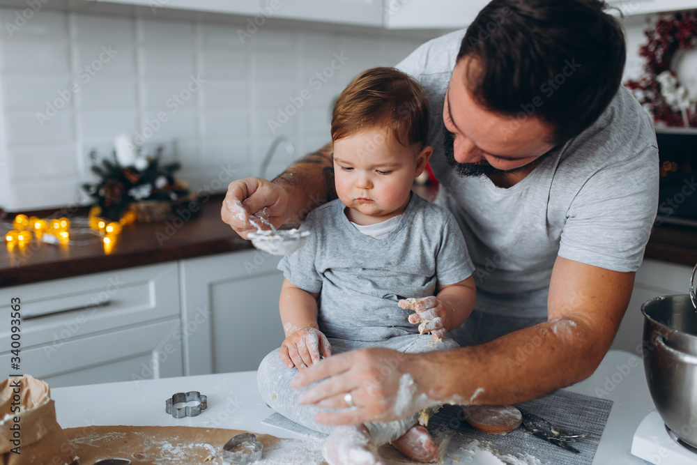 happy family in the kitchen. father and son preparing the dough, bake cookies happy family in the kitchen. father and son preparing the dough, bake cookies