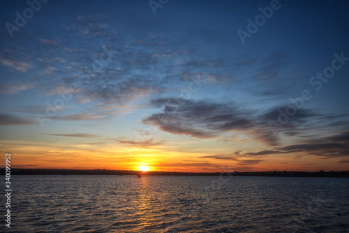 Beautiful sunset on the lake with clouds and reflections on the water © pobaralia