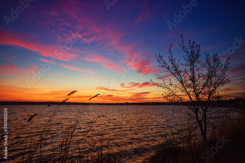 Beautiful sunset on the lake with clouds and reflections on the water