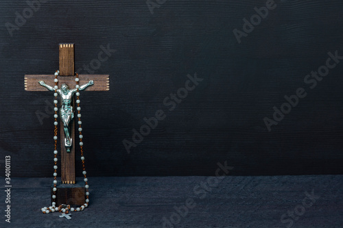 Christian cross and rosary beads on wooden vintage background photo