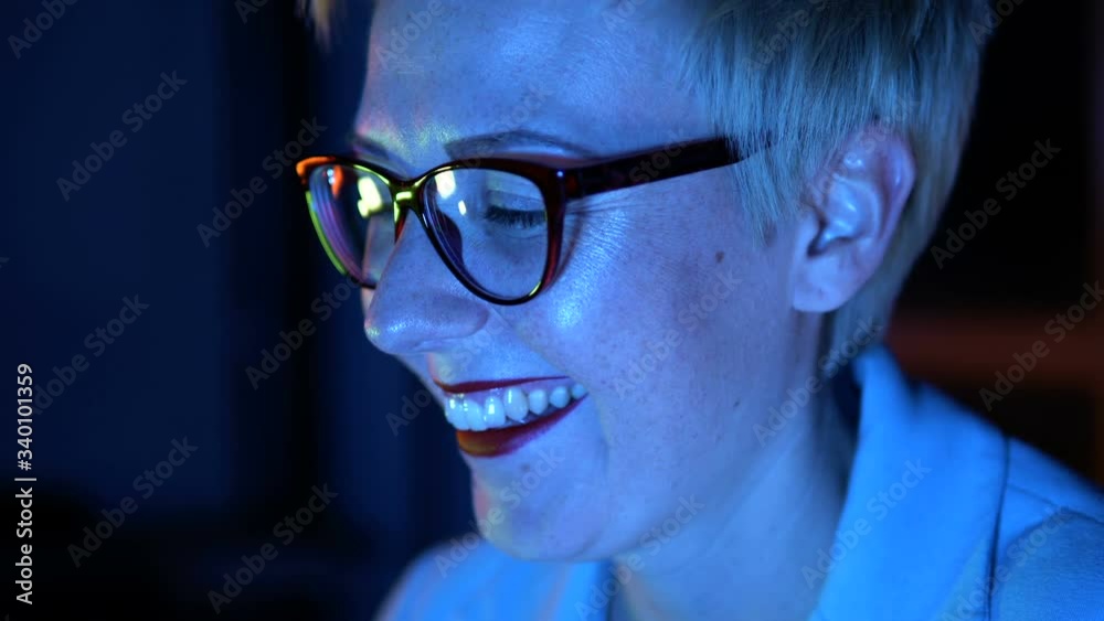 Woman in glasses smiling, chatting with friends in social networks, close-up Woman in glasses smiling, chatting with friends in social networks, close-up