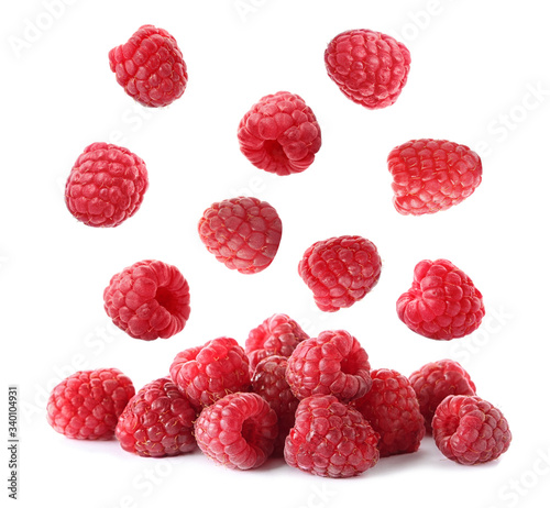 Set of falling sweet raspberries on white background