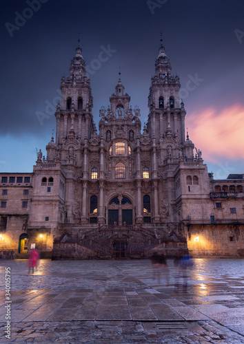 People is crossing the Obradoiro square in the final step of santiago pilgrimage path  making ghost shadows in this rainy day. All to see the Cathedral of Santiago   placed in A Coru  a  Galicia.