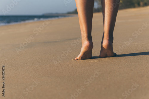 Barefoot woman walking on the beach during sunset,Back view,Vacation and holiday concept