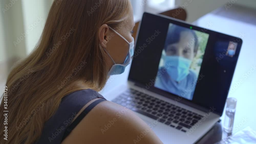 A young woman talks through video conferencing while she is sitting at home during the coronavirus self-isolation period. Social distancing concept A young woman talks through video conferencing while she is sitting at home during the coronavirus self-isolation period. Social distancing concept