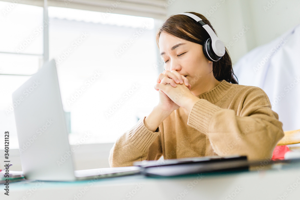 Woman girl stay at home wearing headphone pray and worship GOD with laptop.Prayer girl worship and pray from home for coronavirus crisis.Home church, Church online, Praying hands, Worship at home Woman girl stay at home wearing headphone pray and worship GOD with laptop.Prayer girl worship and pray from home for coronavirus crisis.Home church, Church online, Praying hands, Worship at home