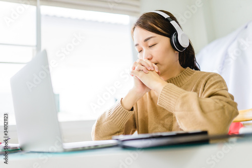 Woman girl stay at home wearing headphone pray and worship GOD with laptop.Prayer girl worship and pray from home for coronavirus crisis.Home church, Church online, Praying hands, Worship at home