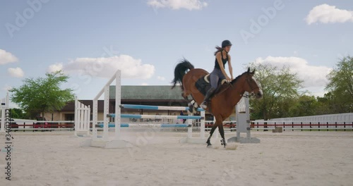 Girl horseback riding in equestrian course photo