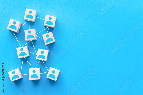 Connecting people or social media networking concept using wood square block on blue background © Kenishirotie
